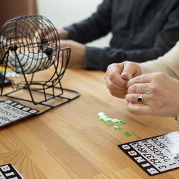 Personen spielen Bingo am Tisch