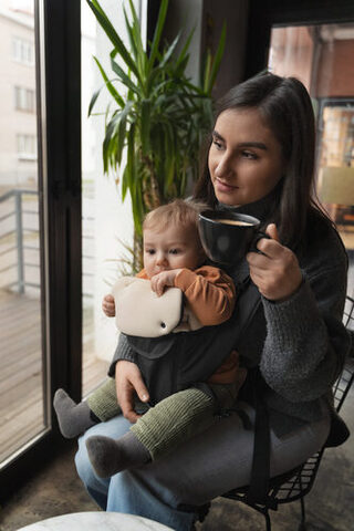 Mutter im Elterncafé mit Baby auf dem Schoß