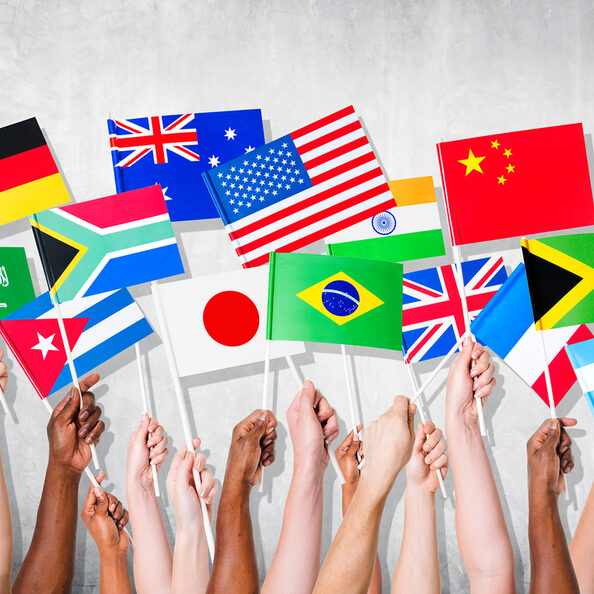 Hände mit Flaggen verschiedener Nationalitäten