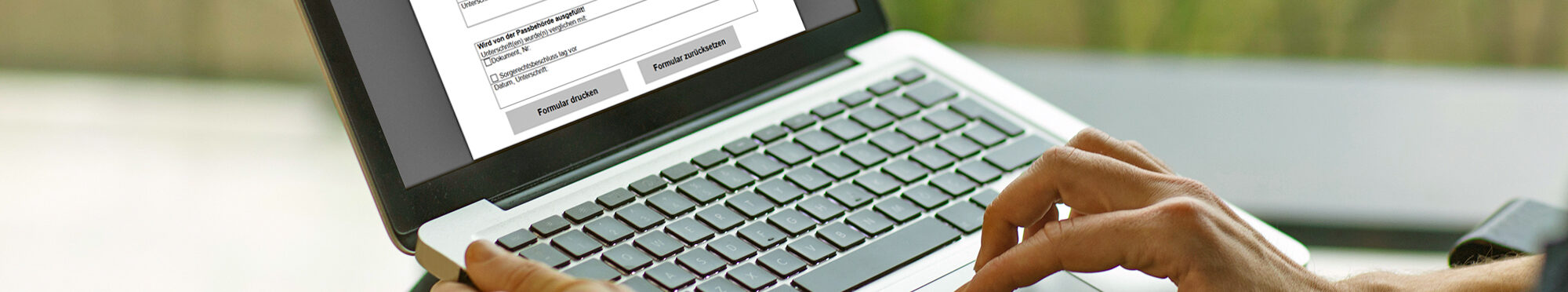 Laptop auf Schoß mit geöffnetem Internet-Formular auf dem Bildschirm