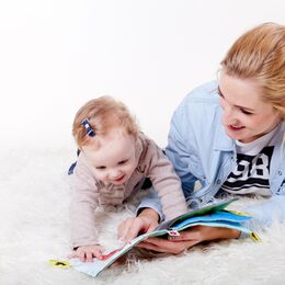Frau mit Kind liegend in ein Buch schauend